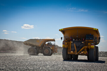 Large trucks transport gold ore from open cast mine. Barrick Cowal Gold Mine in New South Wales, Australia.