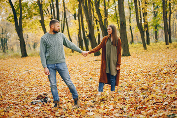 Couple in a park. Woman in a brown sweater. Man with a beard