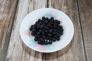 Pile of fresh and organic blueberry on the plate. Famous traditional fruit in America. High vitamin with sweet and sour tasty. 