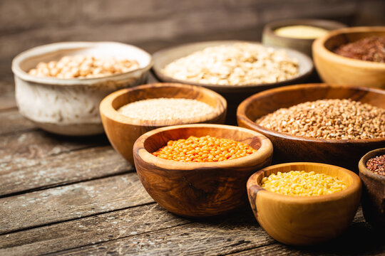 Organic products. Bowls with different gluten free grains on wooden background