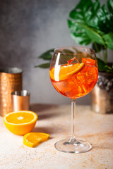 Aperol spritz cocktail in glass with fresh orange on gray background