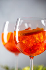 Aperol spritz cocktail in glass with fresh orange on light background