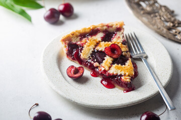 piece of Delicious homemade classic cherry pie with a flaky crust on white background