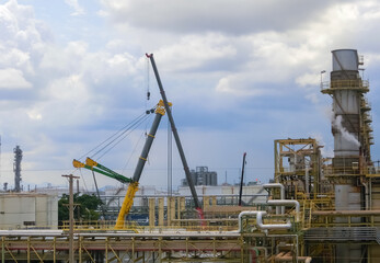 Fototapeta na wymiar Petrochemical plant that is being built using a crane to lift loads