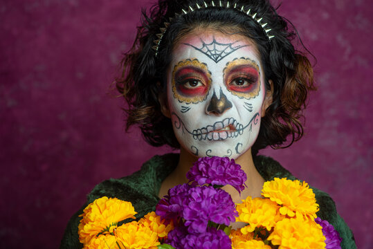 Mujer joven millennial bonita maquillaje catrina mexicana latina día de los muertos halloween cara pintada festividad disfraces punk moderna urbana modelo expresión flores colores cempasúchil sarcasmo