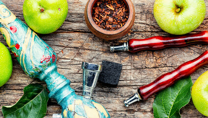 Smoking shisha on green apple