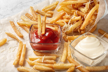 French fries with salt and cream cheese with sauce on the table. French fries sprinkled with salt. French fries with ketchup.