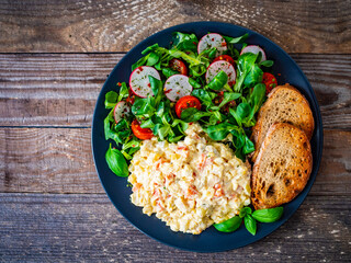 Vegetable mayonnaise salad with toasts on wooden table
