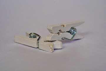 Two white clothespins lie on a white background.