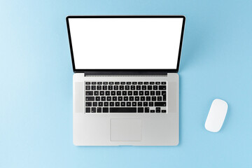 Modern laptop with empty screen on blue background with computer mouse. Office desktop concept. Top view