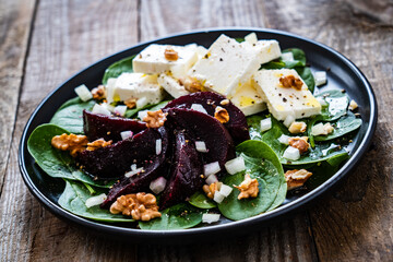  Beetroot salad with feta cheese on wooden background
