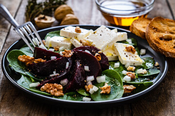  Beetroot salad with feta cheese on wooden background
