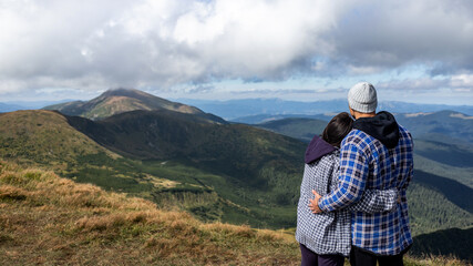 Naklejka premium happy young couple traveling in the mountains, enjoy the landscape