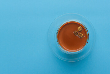Coffee Tiramisu dessert in glass witj golden chocolate coffee beans. Traditional coffee flavored Italian dessert.