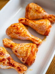 Marinated raw chicken drumsticks ready to roast
