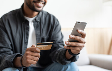 Man holding credit card and using smartphone at home, businessman shopping online, e-commerce, internet banking, spending money, working from home concept