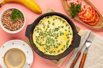 Healthy breakfast - frittata with buckwheat cereal, vegetables and coffee  on pink background. Top view