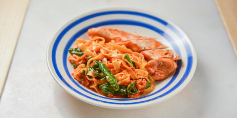 Spaghetti with basil garnish in meat sauce. Traditional Italian pasta with grilled meat.