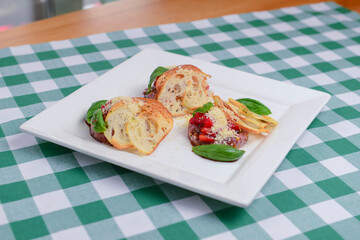 Traditional Italian appetizer Bruschetta with roasted tomatoes, mozzarella cheese, strawberry, garlic and herbs.