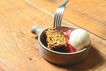 Brownie dessert with ice cream and fresh organic strawberry. Served in a traditional bowl. Georgian cuisine concept.