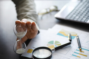 Working time symbolizes an hourglass. Office desk of insurance manager and banker. Office employee at the table. The concept of lack of time.