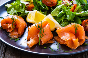 Salmon salad - smoked salmon with vegetables on wooden table