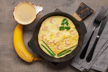 Healthy breakfast - omelette with shrimp, coffee and banana on the table. Top View