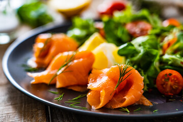 Salmon salad - smoked salmon with vegetables on wooden table