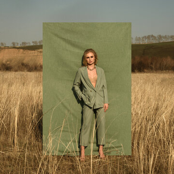 Fashion shooting. The girl in the suit. Fabric background and nature