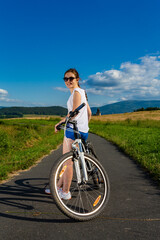 Young woman riding a bicycle on country road
