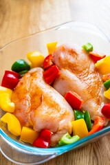 Raw chicken breasts with spices and vegetables baking pot