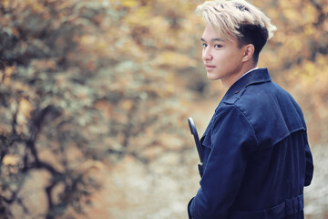 Autumn rainy weather and a young man with an umbrella