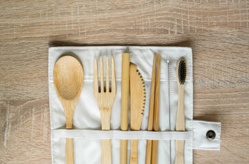 Eco friendly bamboo cutlery set in a case on a table. Zero waste concept. Set of bamboo cutlery in a case on a laying on a table. Spoon, fork, knife, toothbrush, tube and chinese sticks.