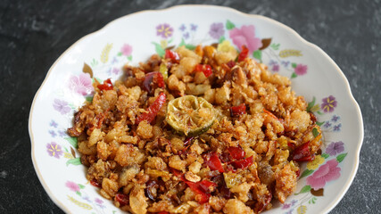 Salted shredded fish or abon is a traditional Indonesian food made from mashed salted fish, it tastes salty, spicy and delicious. Served on a white plate and stone pad.