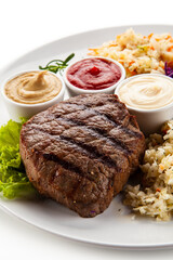 Barbecue beef steak with mix salad, mustard,  mayonnaise and ketchup on white background