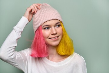 Portrait of trendy teenager girl with colored dyed hair in knitted hat