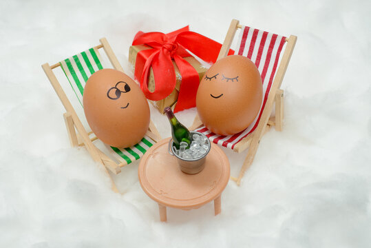Funny lovely eggs in snow with gift box and bottle of wine