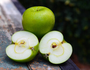 Delicious fruit apples are beneficial to the body, placed on a wooden table in the garden.