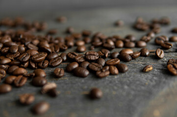 Roasted arabica coffee beans scattered on a wooden table. Fresh coffee beans.