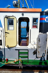 Entrance to the ship control bridge on a small old cutter in the port on the Baltic Sea.