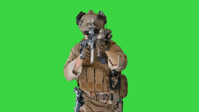 Soldier shoots aming and shooting with rifle on a Green Screen, Chroma Key.