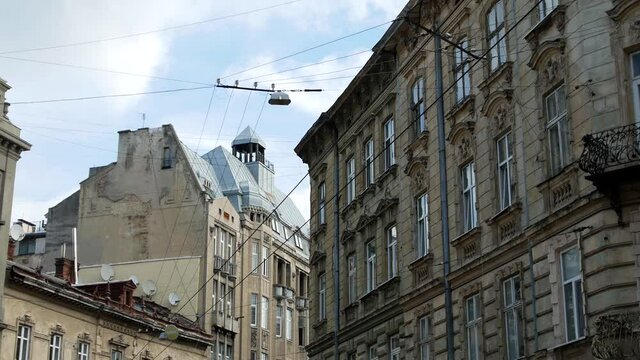 Urban view of an old European city. Vintage lanterns, wires, antennas and many windows on old buildings and houses.