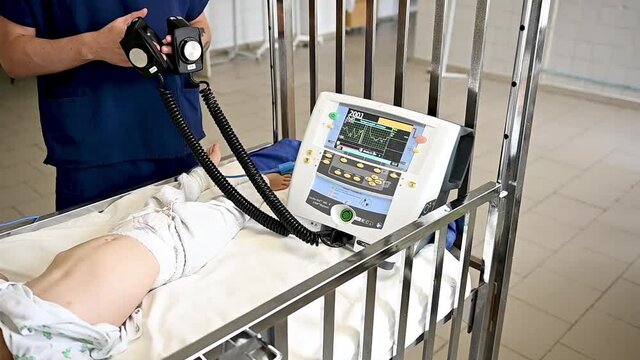 Doctor give resuscitation to a male patient in the emergency room. Cardiac massage. Defibrillation