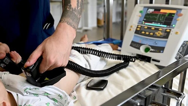 Doctor give resuscitation to a male patient in the emergency room. Cardiac massage. Defibrillation