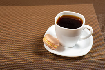 a white cup of coffee and macaroon