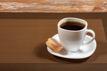 a white cup of coffee and macaroon