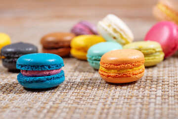 Colorful france macarons on wooden background - selective focus