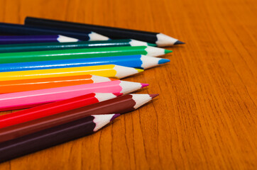 Obraz premium Color pencils on wooden background with copy space for text, banner design
