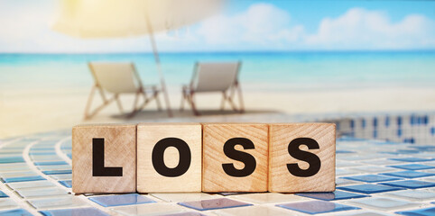 Wooden cubes with word LOSS aver beach landscape.unprofitable business concept. - obrazy, fototapety, plakaty