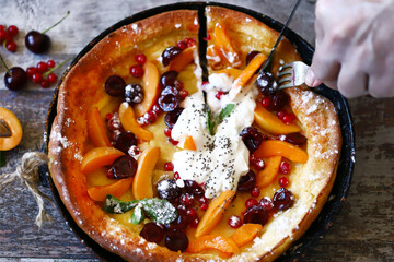 Delicious Dutch baby pancake with fruit and ice cream. Homemade fruit pie.